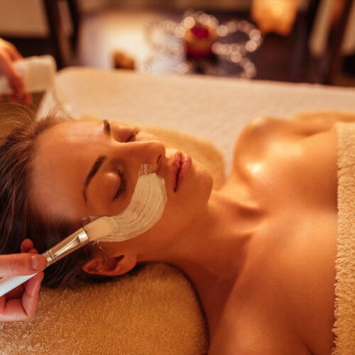 Attractive young woman enjoying a face treatment at a spa